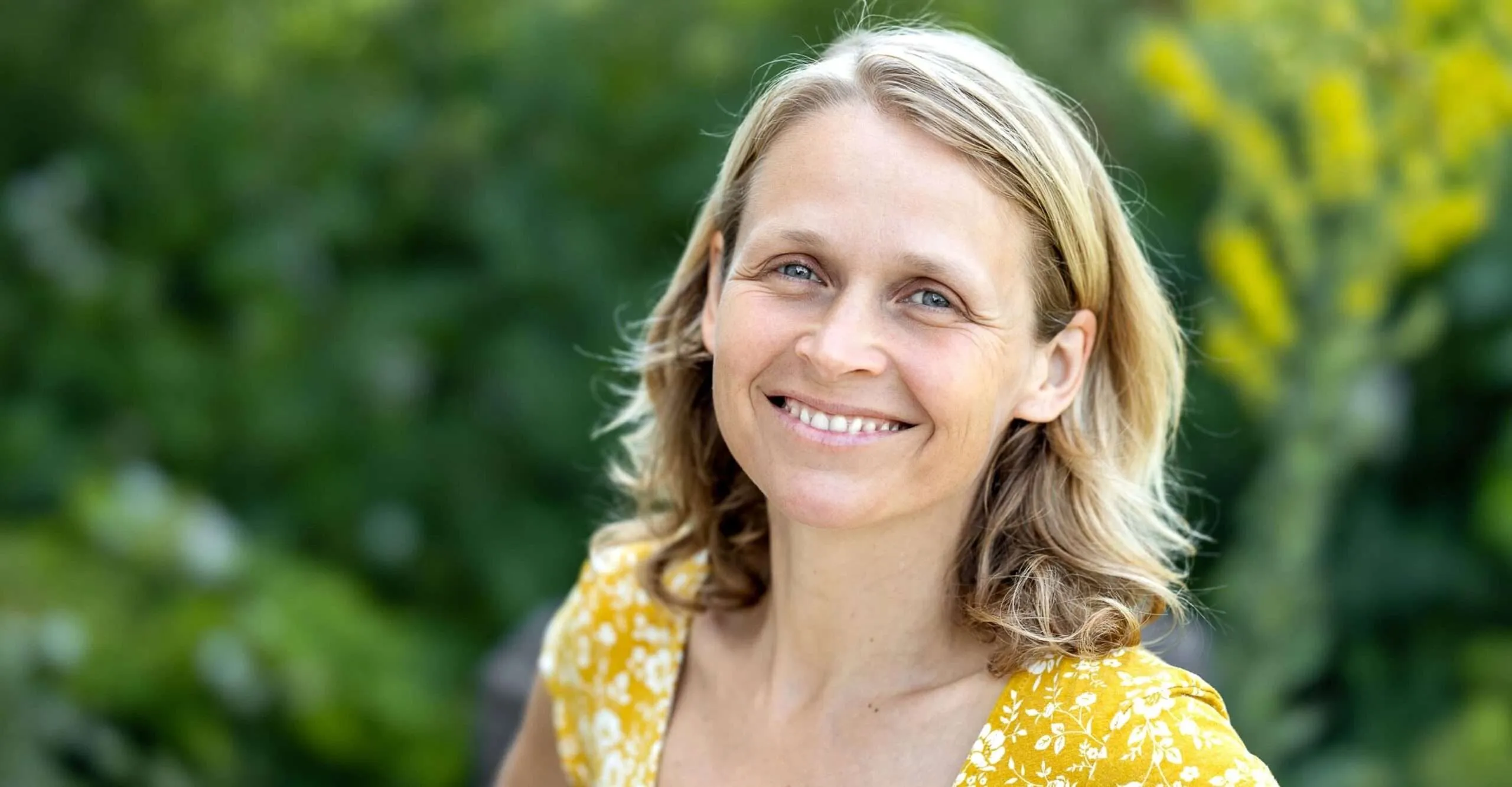 Irma Pelikan lächelt in einem sommerlichen Garten